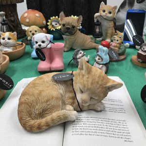 動物フィギュア｜woobia 眠っている茶トラの子猫の置物。開いた本の上に乗っています。