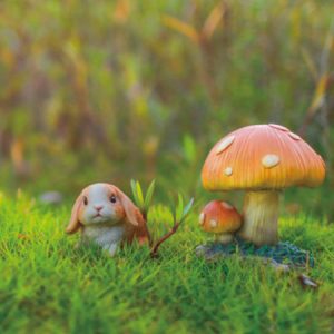 動物の置物｜うさぎとキノコの置き物。大小のキノコの隣に佇むロップイヤーのかわいいうさぎの置き物が庭の芝生に置かれています。